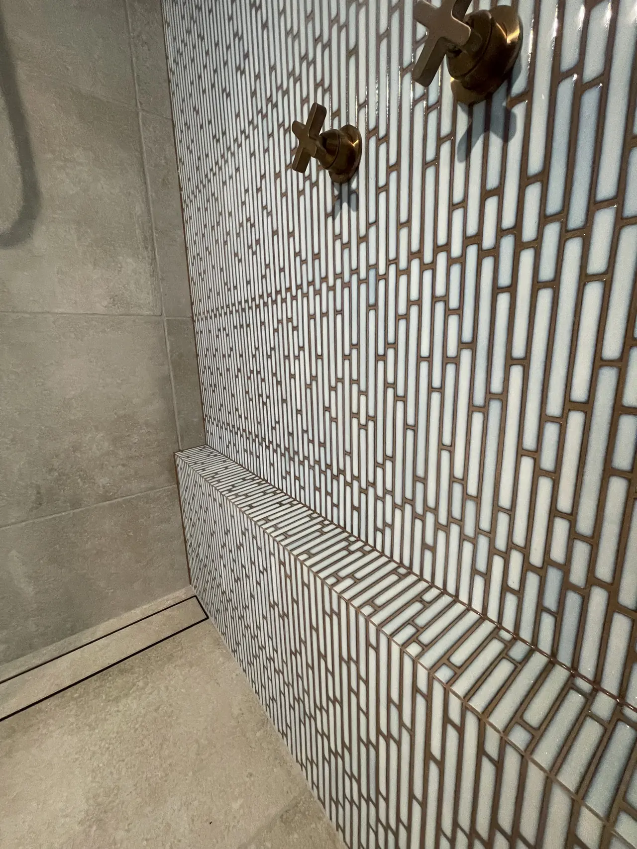 Finger-tile feature wall with brass tapware