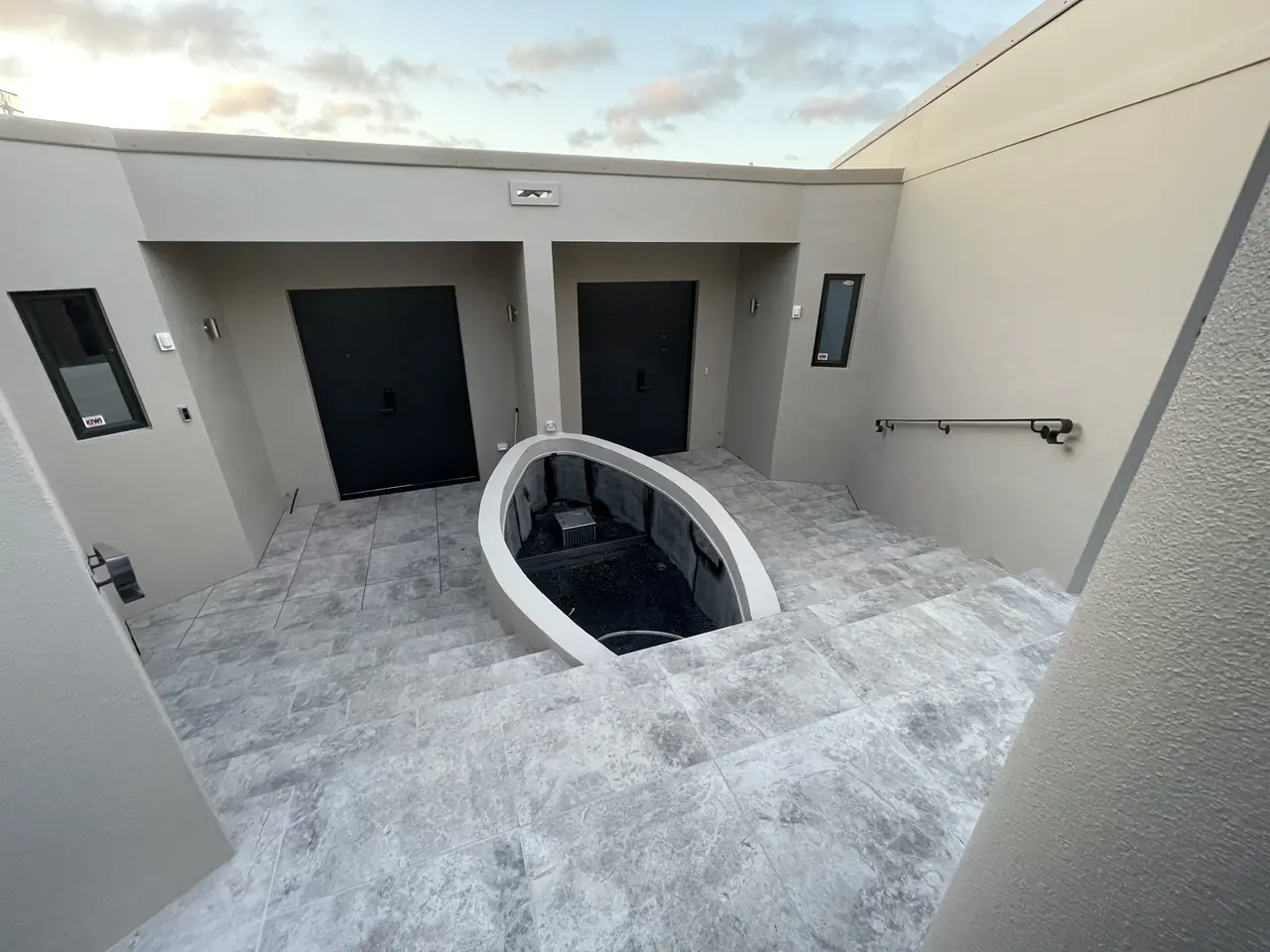 Natural stone courtyard with curved planter at dusk