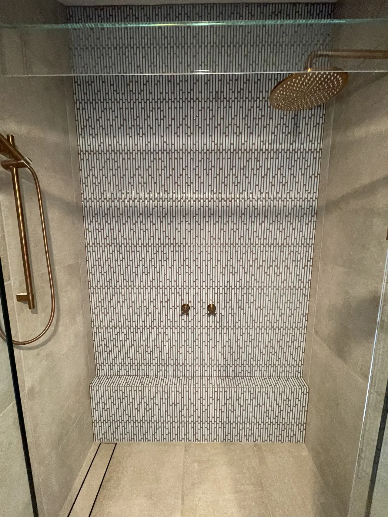 Patterned feature wall in shower with brass fittings