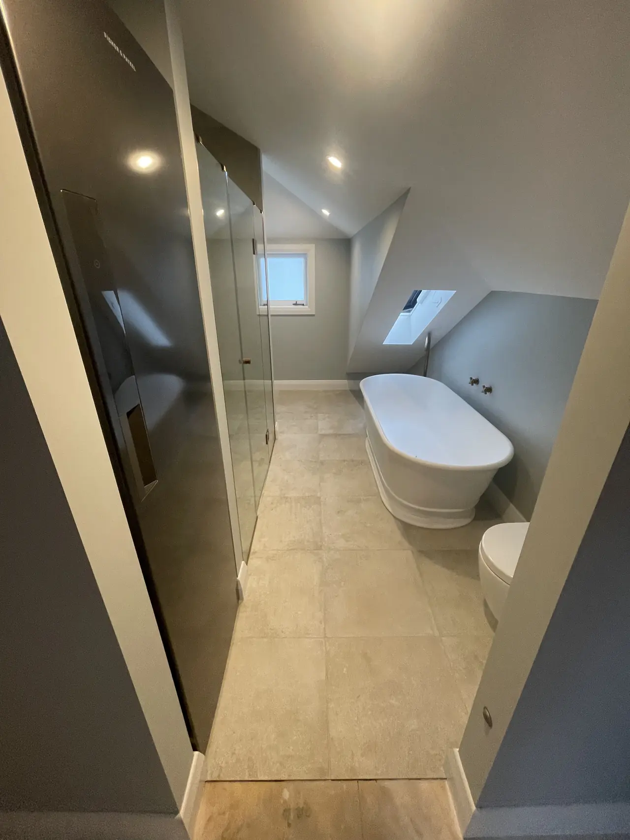 Bathroom with freestanding bath and large tiles