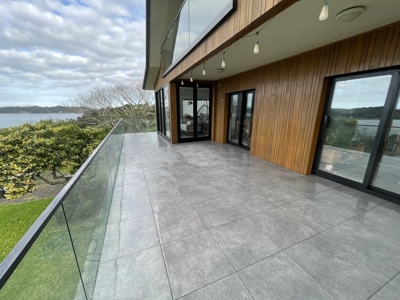 Large format porcelain terrace with glass balustrade overlooking the harbour