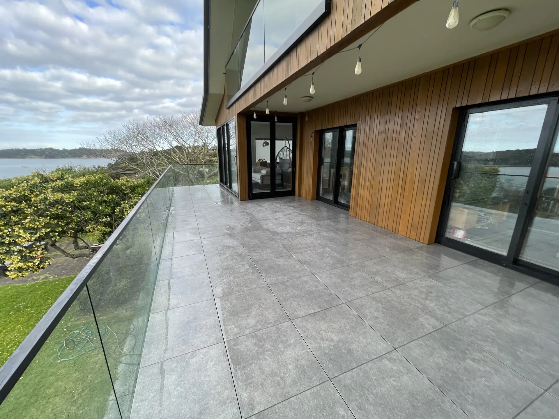 Large format porcelain terrace with glass balustrade overlooking the harbour